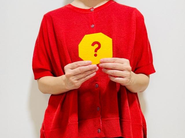 ？マークのカードを持った女性の画像