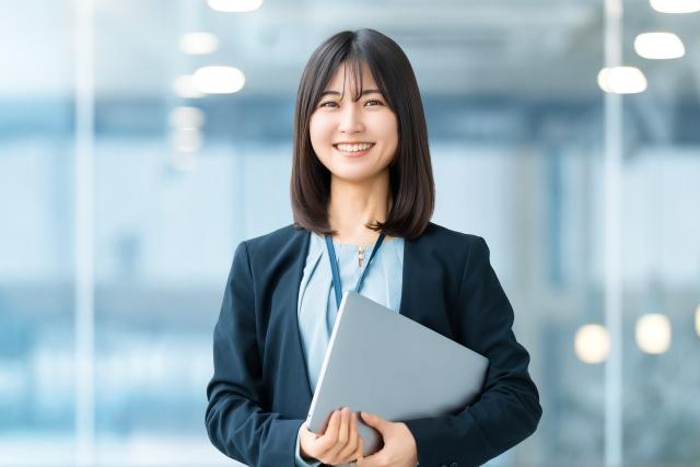 パソコンを持つ笑顔の女性